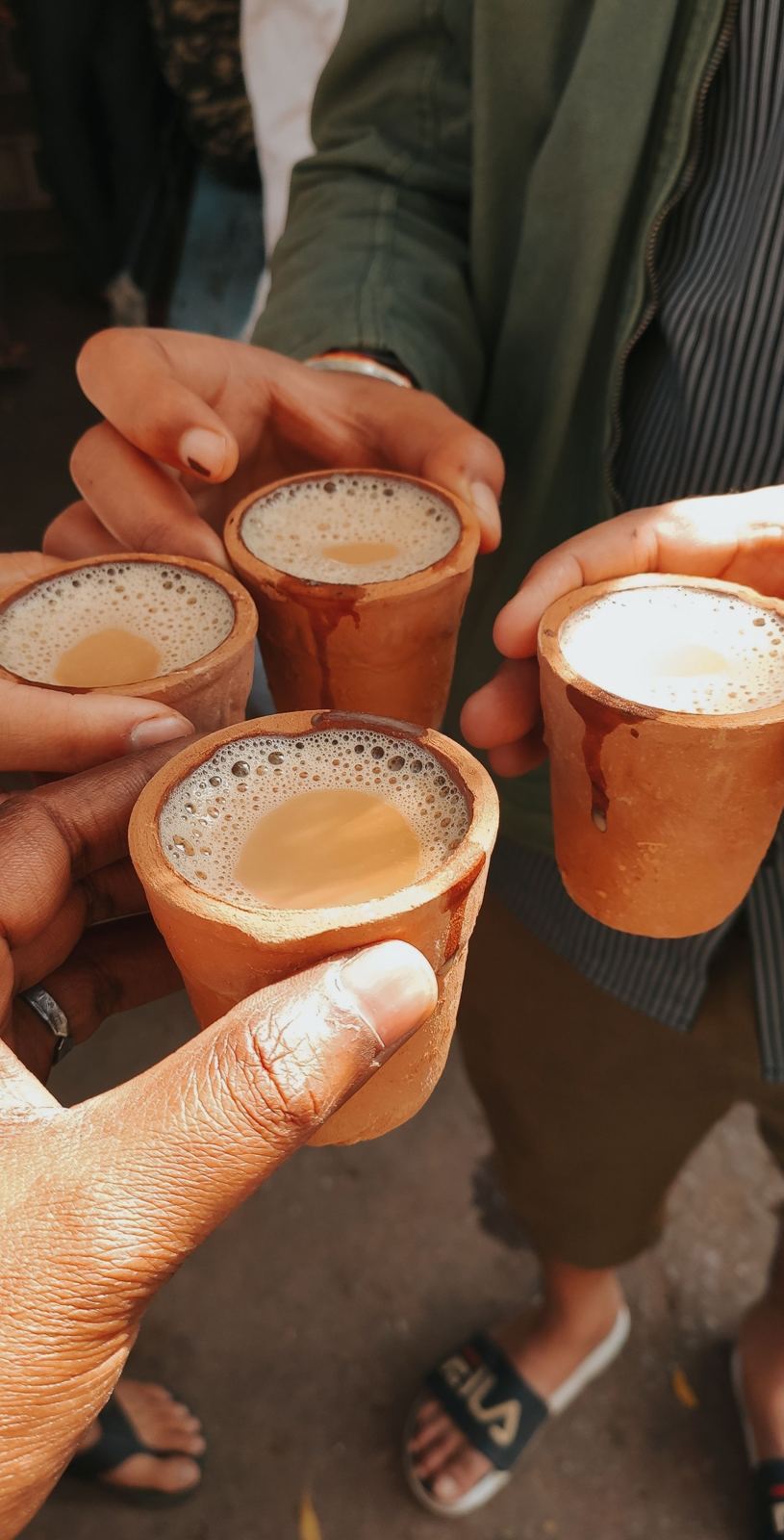 Friends toasting with masala chai in clay cups