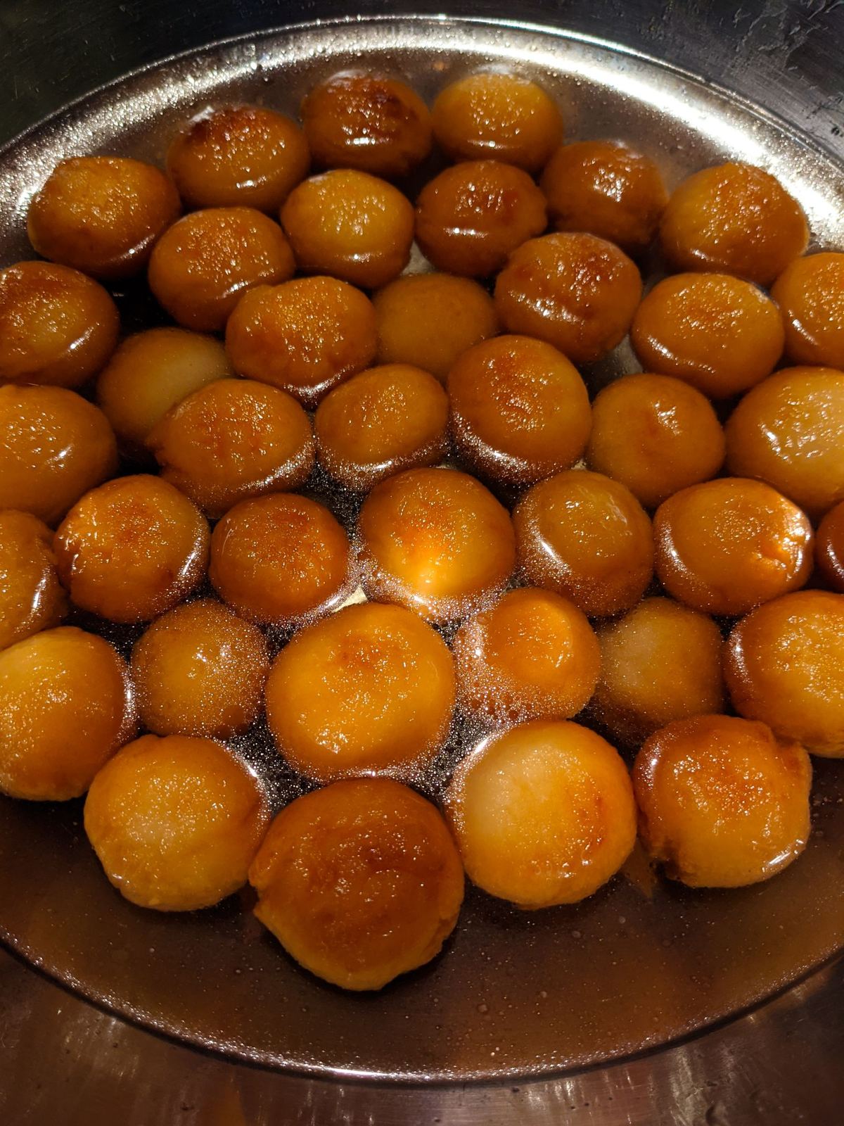 Gulab jamun in syrup in a steel bowl